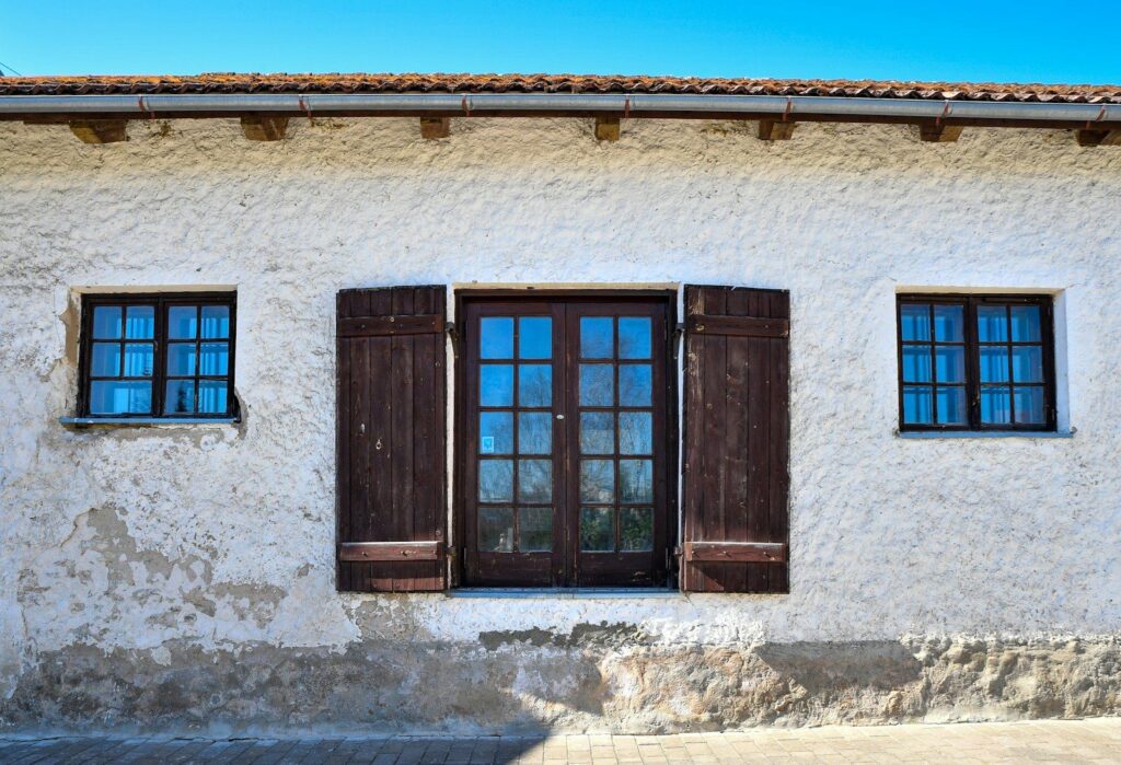 Verputzte Hausfassade mit Fensterläden